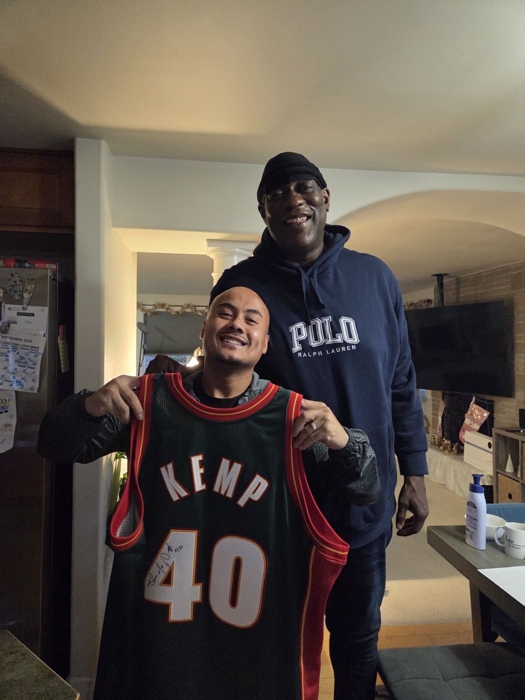 A friend holding up a Kemp number 40 jersey next to Shawn Kemp