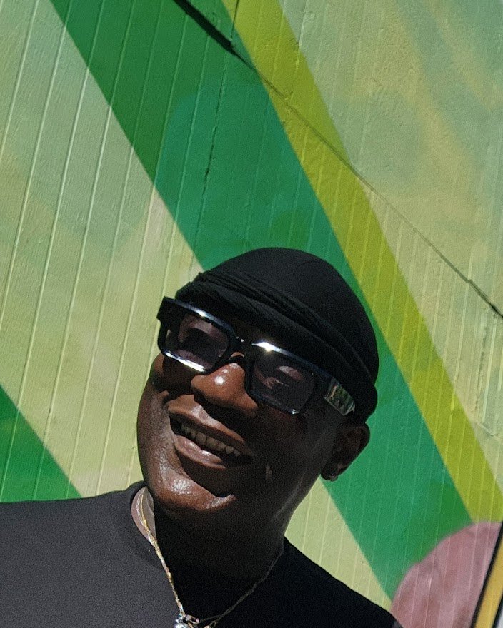 Shawn Kemp smiling in front of a painted basketball mural