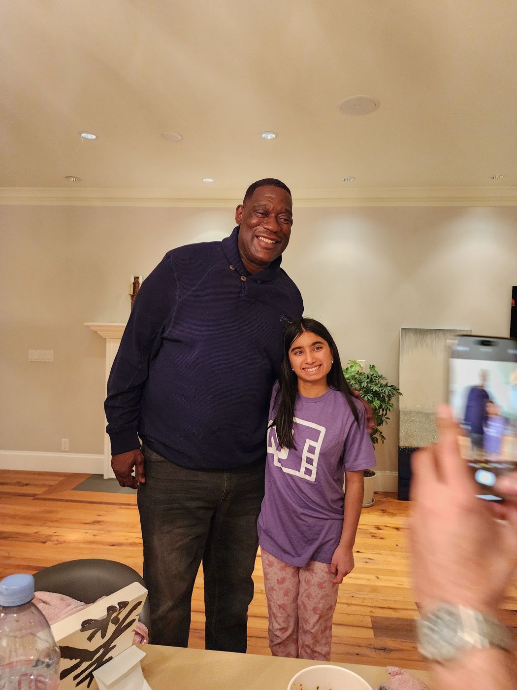 Shawn Kemp standing with a smiling girl at a home gathering